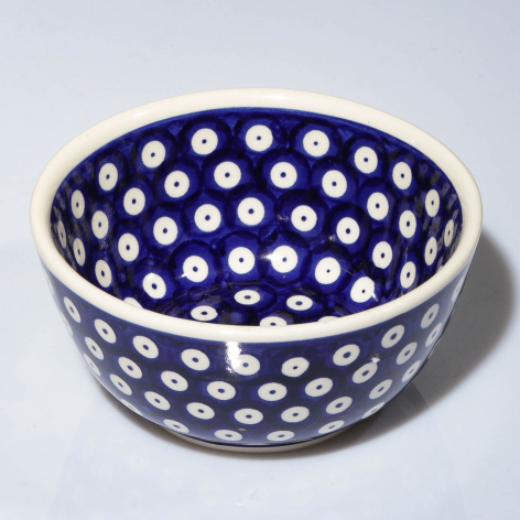 Deep blue ceramic bowl with white polka dot pattern, viewed from above at slight angle