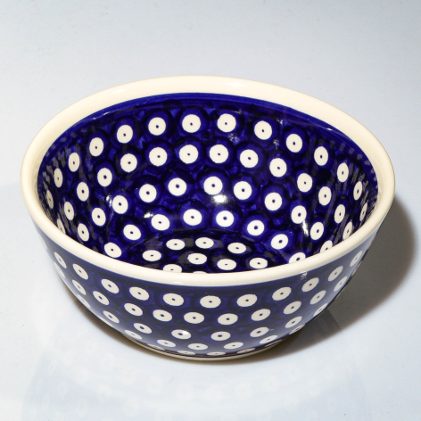Deep blue ceramic bowl with white polka dot pattern throughout, shown from above at slight angle