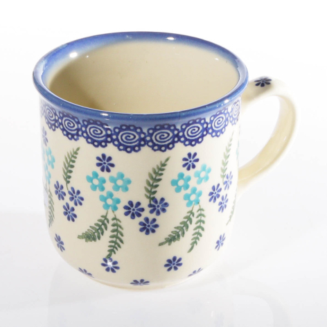 Cream ceramic mug with blue rim and delicate blue and green floral pattern, front angled view