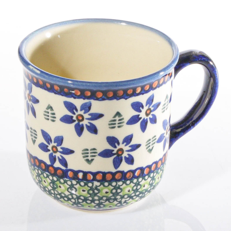 Blue and white ceramic mug with cobalt floral pattern and green geometric band, front view
