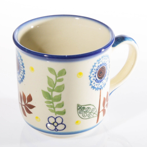 Cream-colored enamel mug with blue rim and handle, decorated with colorful folk flower motifs