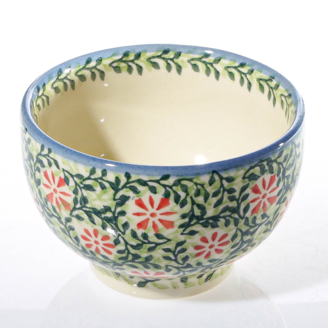 Cream ceramic bowl with blue rim and hand-painted floral pattern of pink flowers and green leaves, three-quarter view