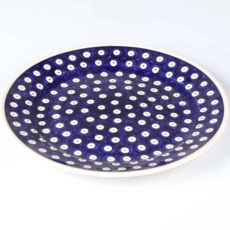 Deep blue ceramic bowl with white polka dot pattern, overhead view showing perforated design