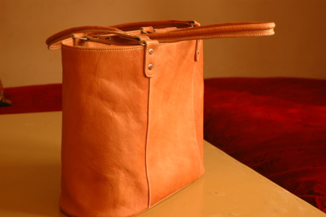 Burnt orange leather crossbody bag with structured rectangular shape and adjustable shoulder strap, front view