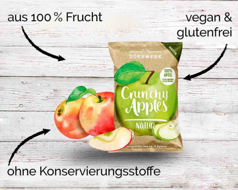 Packung getrocknete Apfelchips auf weißem Holzuntergrund mit frischen Äpfeln und Beschriftungen zu Inhaltsstoffen