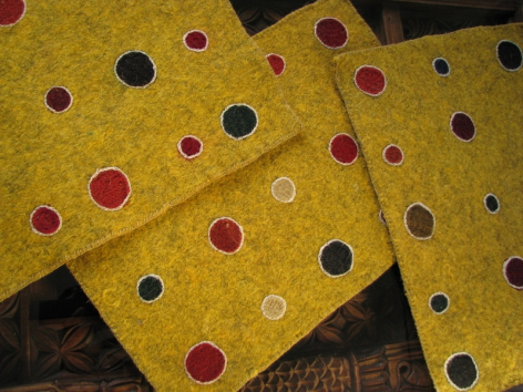 Yellow textile with red, blue, and white polka dots in close-up view, showing woven fabric detail