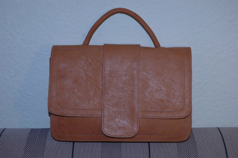Braune Ledertasche aus Leder mit Henkel und rechteckiger Form, Frontansicht auf grauem Hintergrund