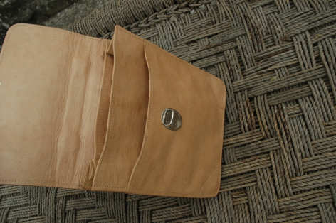 Aufgeklappte Lederhandtasche in Naturton mit metallischem Verschluss, Draufsicht auf geöffnetem Muster