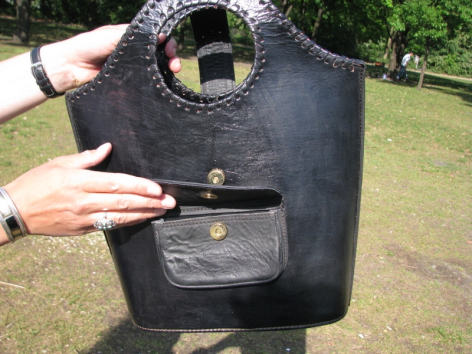 Schwarze Ledertasche mit strukturierter Oberfläche, frontal gezeigt, mit sichtbarer Metallschließe und Tragegriffen