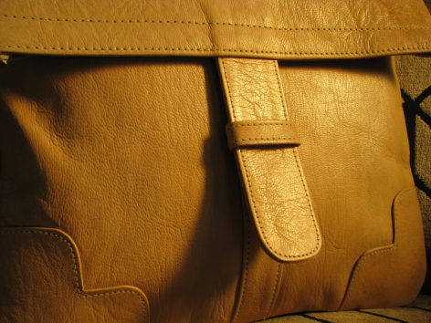 Nahaufnahme einer hellbraunen Ledertasche mit handgenähten Nähten und überlappenden Lederpanelen in Detailansicht