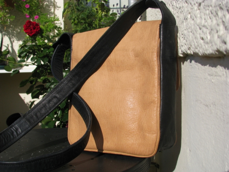 Hellbraune Ledertasche mit schwarzem Schultergurt, Vorderansicht, handwerklich gefertigt
