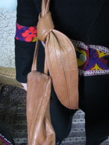 Hellbraune Ledermaske mit kunstvollstem Schnitzwerk, handgefertigt, in traditioneller Hand gehalten