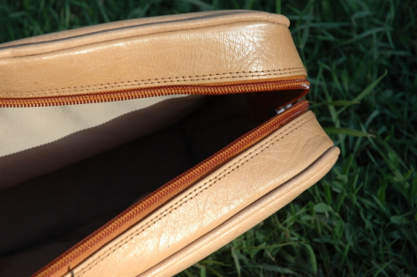 Hellbraune Ledertasche mit schwarzem Innenfutter, Detailaufnahme der oberen Kante und Nähte