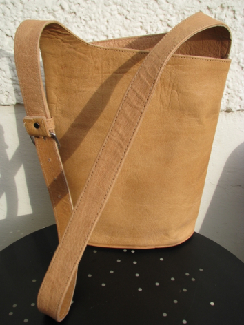Cognacbraune Ledertasche mit Schultergurt, Vorderansicht, zeigt charakteristische Narbung und Patina des Naturleders