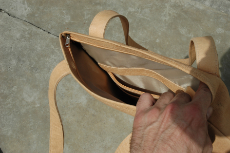 Hellbraune Ledertasche, Vorderansicht offen, zeigt Innenraum und Henkel aus natürlichem Leder