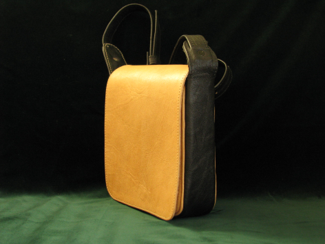 Gelbe Ledertasche mit schwarzem Lederrücken, aufrecht stehend, Vorderansicht mit Tragegriff