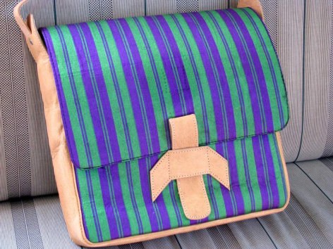 Purple and teal striped textile shoulder bag with geometric cross detail and colorful trim, front view