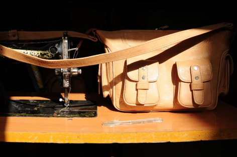 Sac cuir camel à bandoulière avec coutures visibles, accompagné d'une ceinture assortie