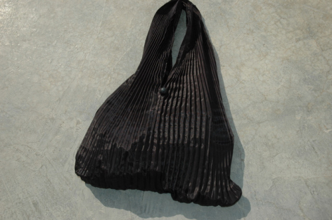 Schwarze Ledertasche mit gerippter Oberflächenstruktur, Draufsicht auf rundes, weiches Design