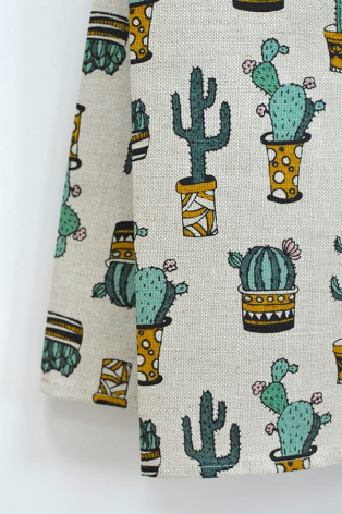 Cream cotton textile with scattered green cactus and gold pot motifs in repeating pattern