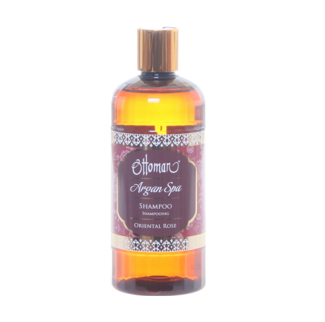 Golden argan oil in glass bottle with purple label and bronze-colored pump dispenser top
