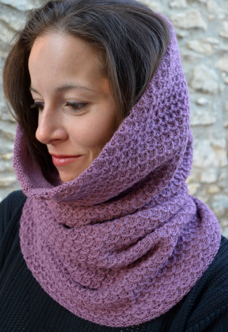 Mauve knitted cowl neck warmer worn around shoulders, close-up side view on model with dark hair