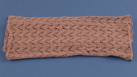 Terracotta woven headband with textured surface, curved rectangular shape, front view