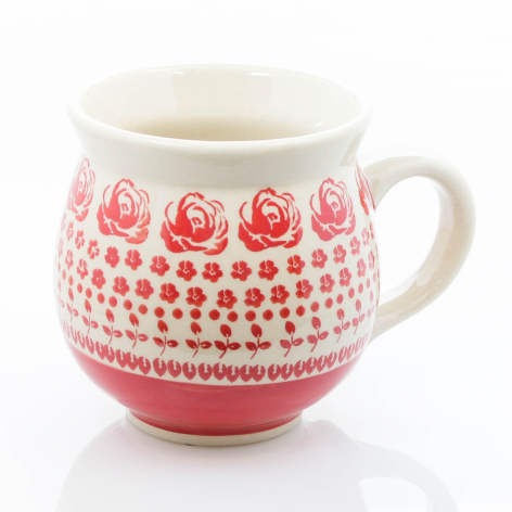 Cream ceramic mug with pink hand-painted floral bands and dotted pattern, rounded bulbous shape with handle