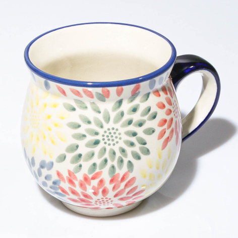 Ceramic mug with cream background and multicolored floral mandala pattern, navy blue rim and handle
