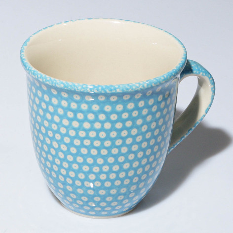 Blue ceramic mug with white polka dot pattern and cream-colored interior, front view