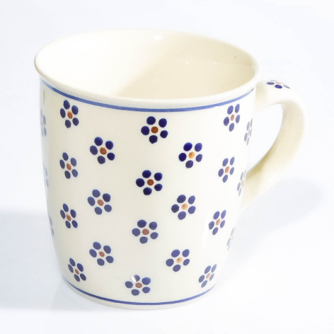 Cream ceramic pitcher with blue floral pattern and curved handle, three-quarter front view