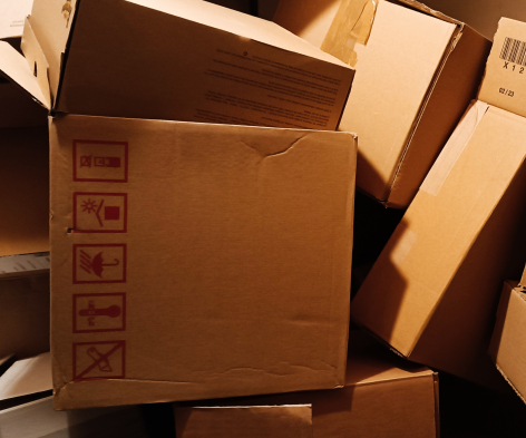Brown cardboard shipping box with embossed text on side, photographed from above at an angle