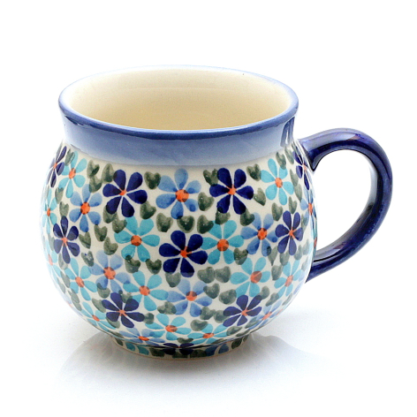 Round ceramic mug in cream with blue rim, decorated with scattered purple and teal floral pattern, front view
