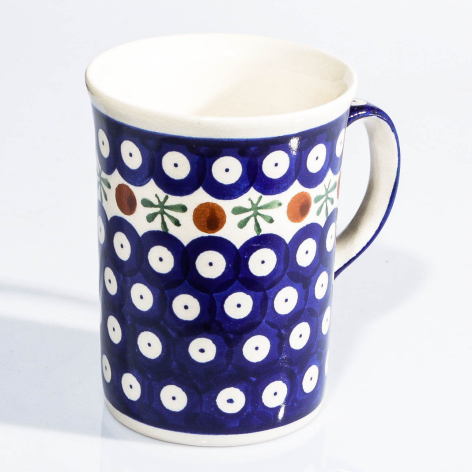 Navy ceramic mug with white polka dot pattern and decorative floral band, front view