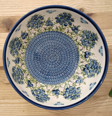 Ceramic serving bowl with blue and cream glaze, featuring intricate floral and geometric patterns in overhead view