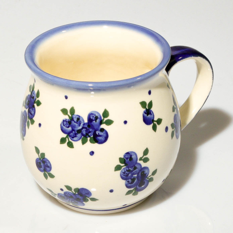 Cream ceramic pitcher with cobalt blue floral design and curved handle, front view