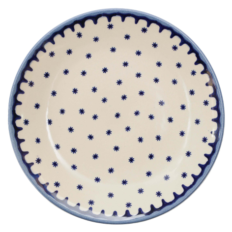 Round ceramic plate with cream background and navy blue dotted pattern, top view