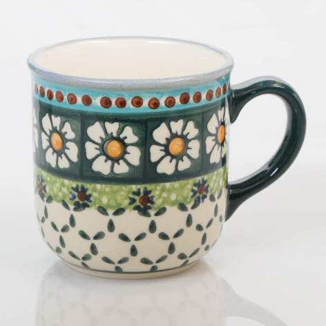 Teal and cream ceramic mug with white daisy flowers and geometric patterns, black handle