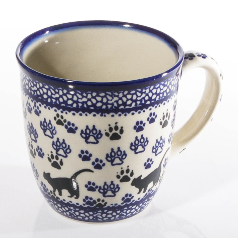 Blue and white ceramic mug with hand-painted floral and animal motifs, cream interior, angled front view