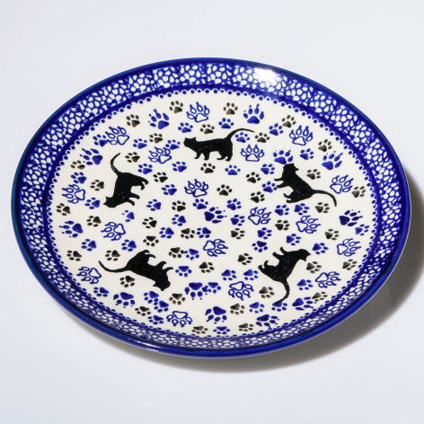 Blue and white ceramic plate with black horse silhouettes and floral pattern throughout, viewed from above