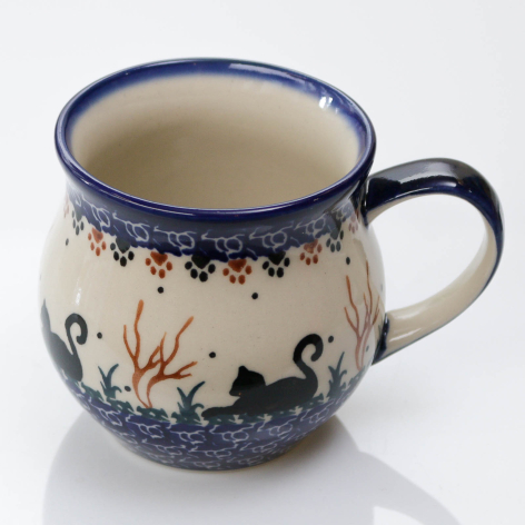 Navy blue ceramic mug with cream glaze and hand-painted floral motifs, rounded belly shape with side handle, front view