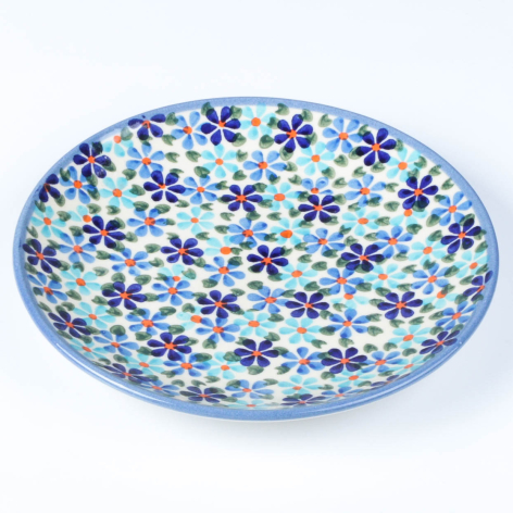 Blue ceramic bowl with purple and green floral pattern, viewed from above at slight angle