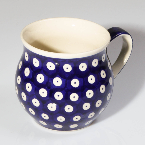 Navy ceramic jug with white polka dot pattern and cream interior, three-quarter view