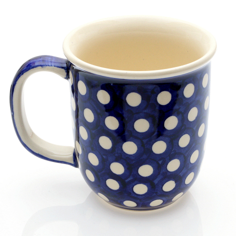 Navy ceramic mug with white polka dot pattern and cream interior, front view