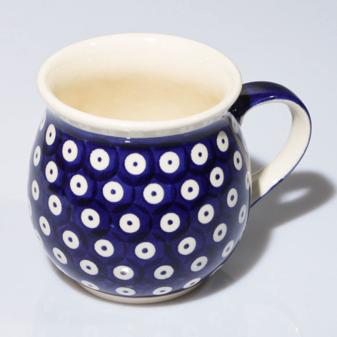 Navy ceramic pitcher with white geometric dot pattern and cream-colored interior, front view
