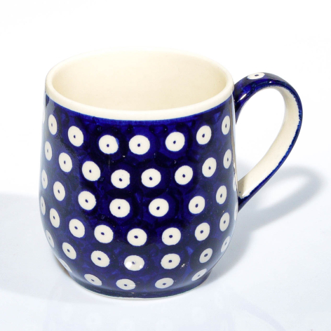 Navy ceramic mug with white polka dot pattern and cream interior, front view