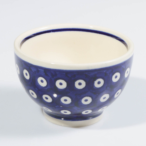 Navy ceramic bowl with cream interior and white circular dot pattern throughout