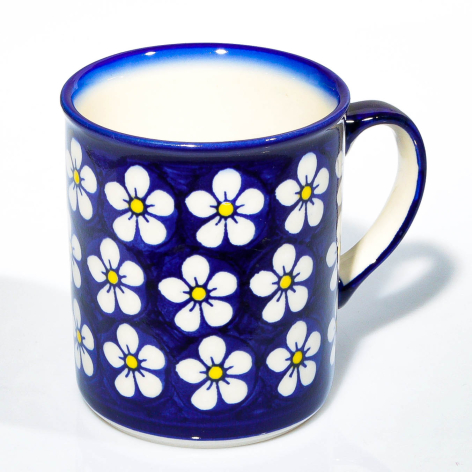 Blue ceramic mug with white and yellow daisy flower pattern, front view