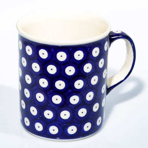 Navy blue ceramic mug with white polka dot pattern and curved handle, front view