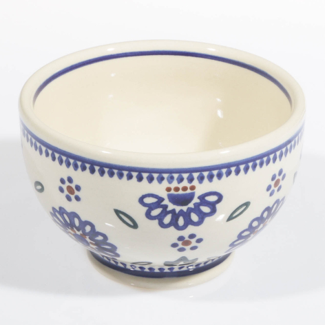 Cream ceramic bowl with blue floral and geometric patterns, wide rounded form with decorative rim